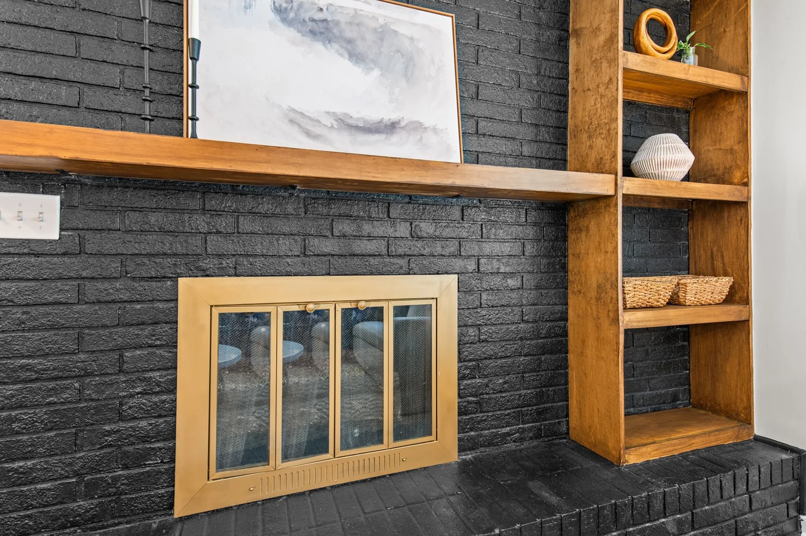 Roxanne: black brick fireplace and wood shelving